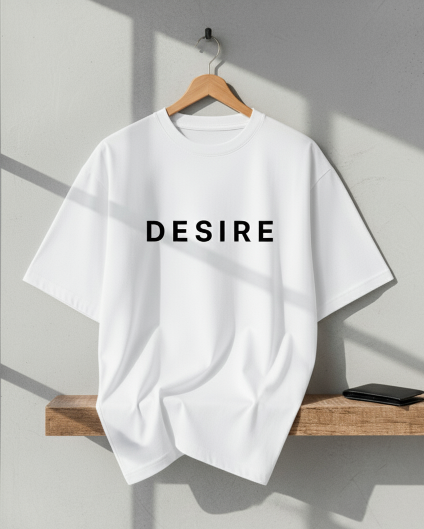 White t-shirt with 'DESIRE' text on a wooden hanger against a gray wall.