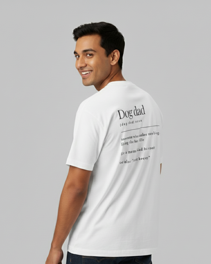 Man wearing a white t-shirt with 'Dog dad' text on the back, standing against a gray background