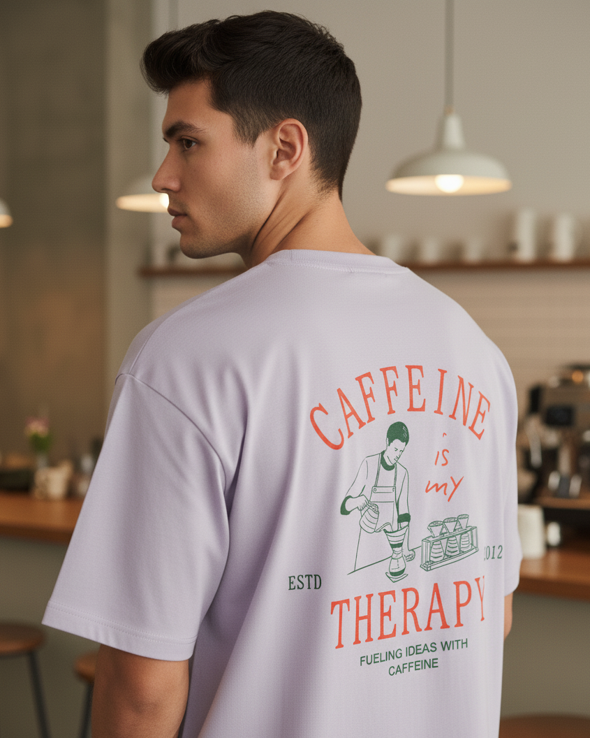 Man wearing a t-shirt with 'Caffeine is my Therapy' design in a cafe setting